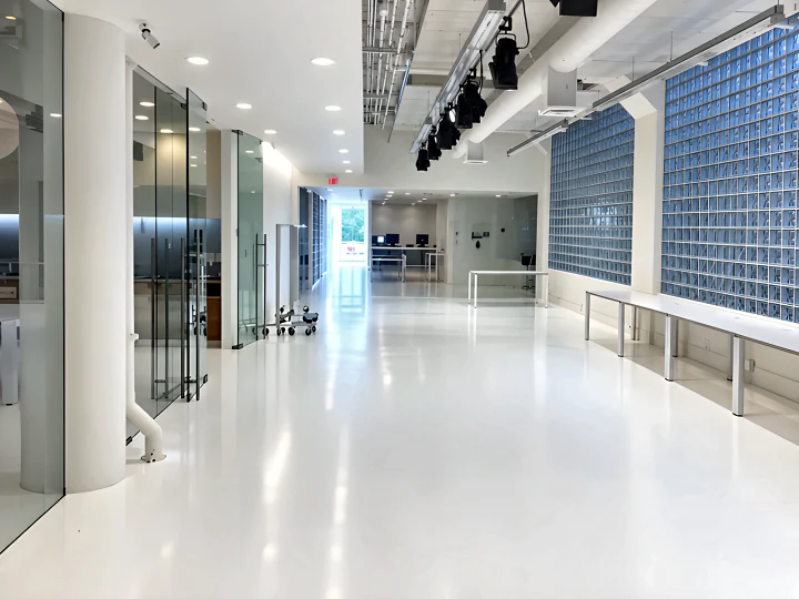 Seamless white resin floor running through a glazed office corridor at the Aritzia head office