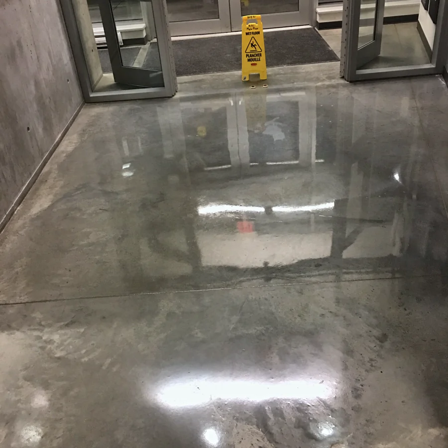 Polished concrete at the entrance of the BCIT Aerospace Technology Campus in Richmond, the doors reflected in it