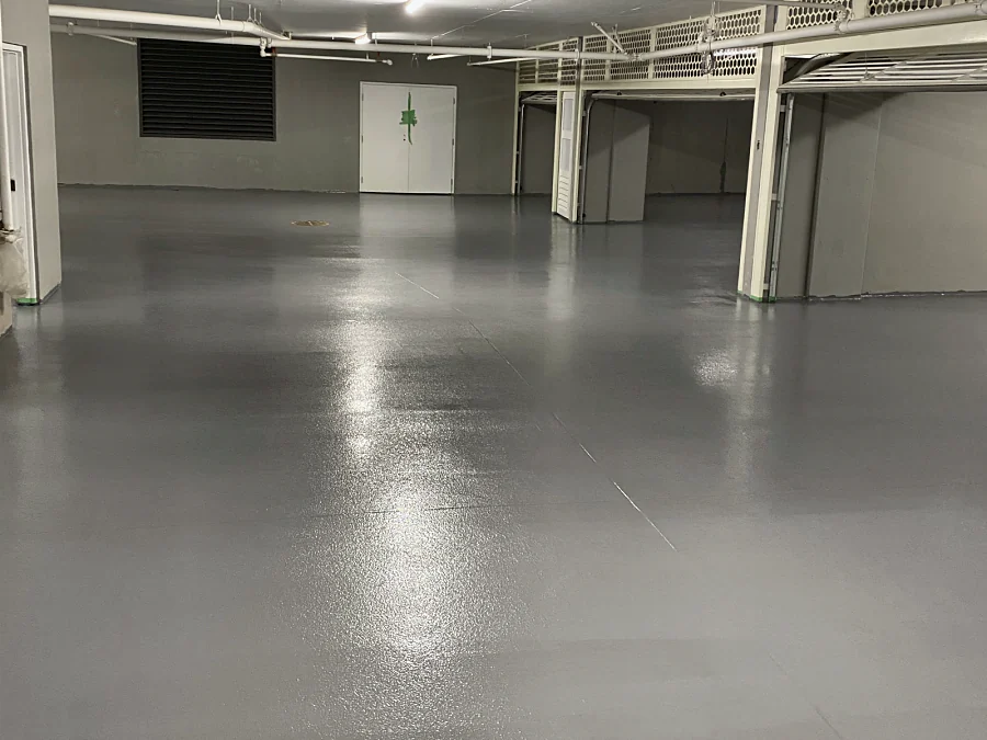 Grey Tremco traffic coating across a parking level at 2289 Bellevue Avenue, West Vancouver, to the double doors at the far end