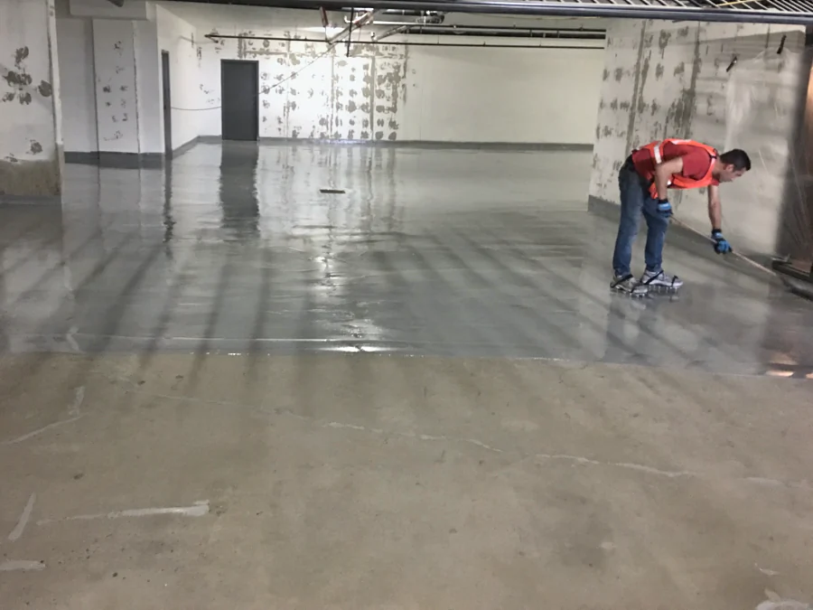 Grey Tremco Vulkem traffic coating going down over the prepared slab of a residential parkade in Brentwood, Burnaby
