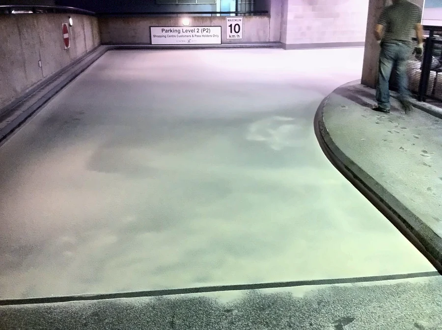 Aggregate broadcast into the traffic coating on the ramp down from Parking Level 2 at the Central City Shopping Centre parkade, Surrey