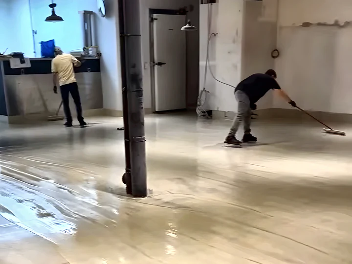 Two installers rolling ResinTech TUE across an open commercial interior