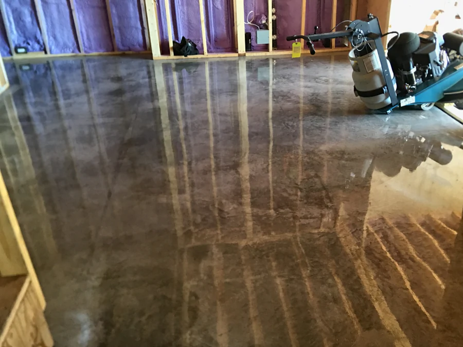 The polishing machine on a cream-polished concrete floor, the studs reflected in the 3,000-grit finish