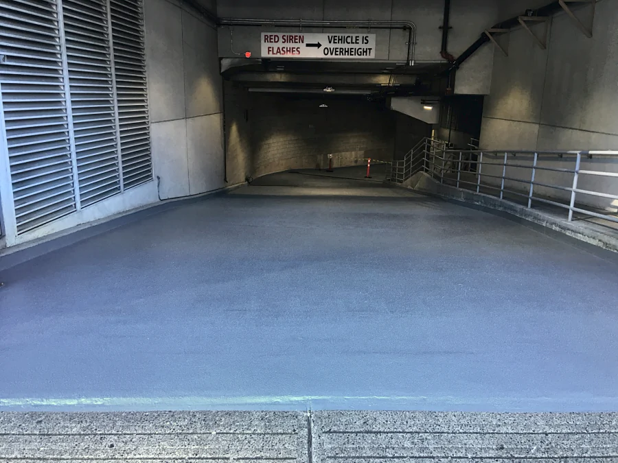 The same Downtown Vancouver parkade entrance ramp coated in a textured traffic coating, under the overheight sign, 2016