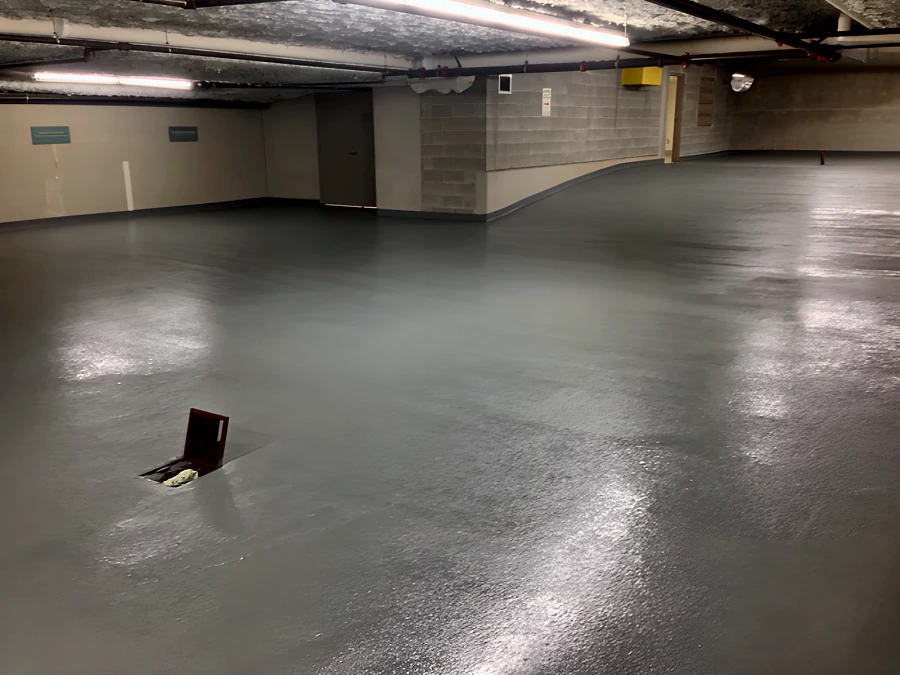 Recoated parking level in a Downtown Vancouver parkade, the grey traffic coating laid around the floor drain