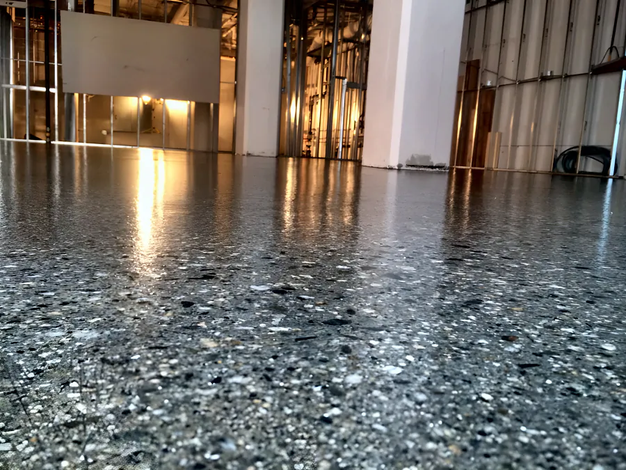 Clear-coated concrete floor running to the open steel-stud walls of a Downtown Vancouver restaurant fit-out