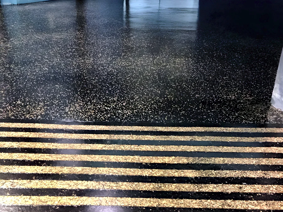 Black random flake floor with gold flake warning strips at Hard Rock Casino Coquitlam