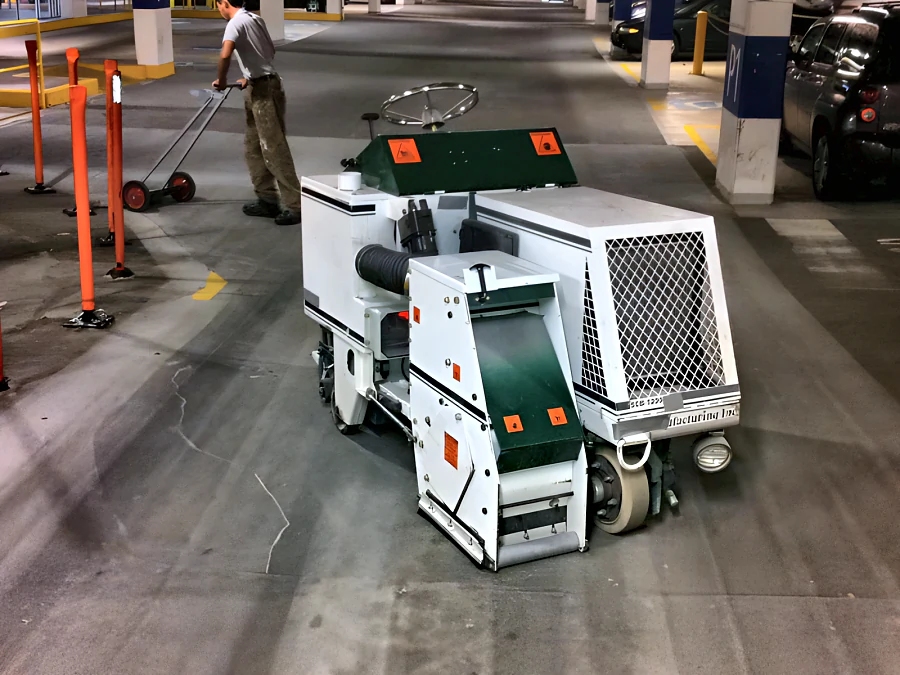 Surface preparation machine working across the International Village parkade deck in Vancouver before recoating