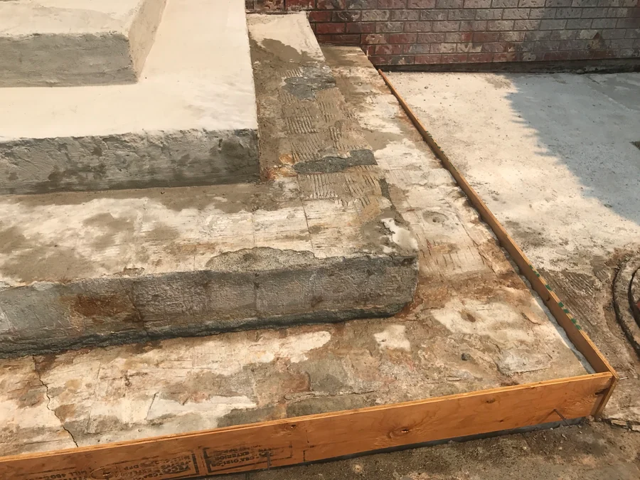 The old concrete front steps of a Kerrisdale house formed up with lumber for repair, the broken concrete cut back