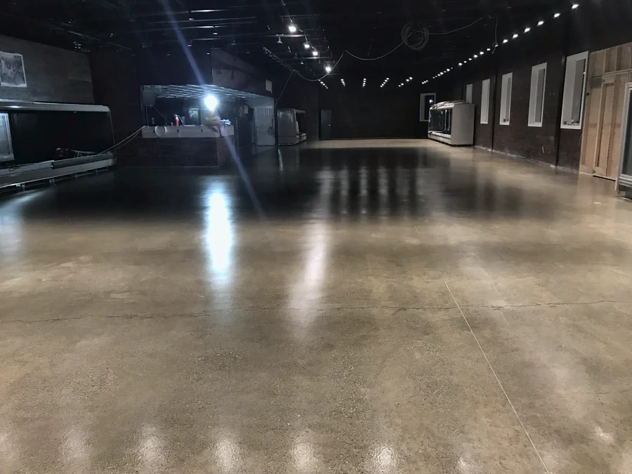 The clear-coated concrete sales floor of a farm market in Langley, glossy under the lights towards the display cases