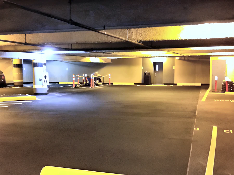 Dark parkade coating at Metrotown with fresh yellow stall and aisle lines