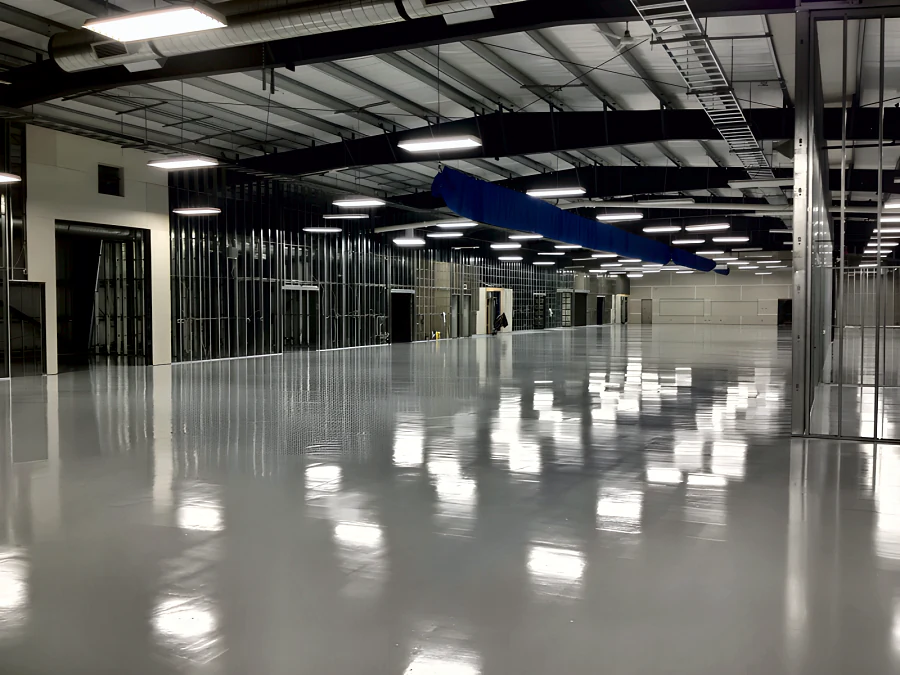 Finished light grey epoxy and urethane floor across the open hall at MTU Canada in Richmond, reflecting the ceiling lights