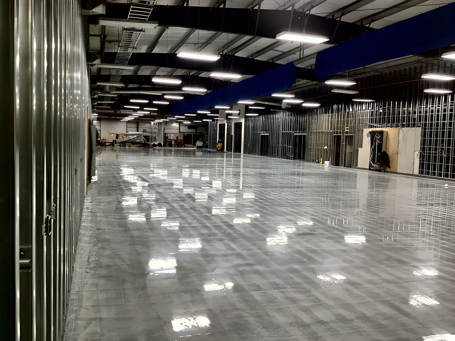 High-gloss light grey epoxy and urethane floor down the length of the MTU Canada building in Richmond, with the interior fit-out still under way