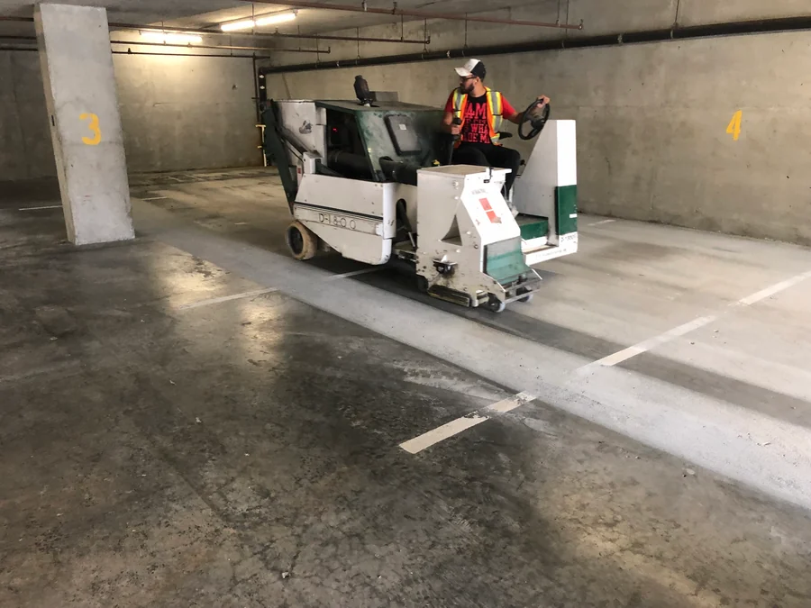The parkade slab being shot blasted with a ride-on blaster before the Tremco Vulkem traffic coating, New Westminster