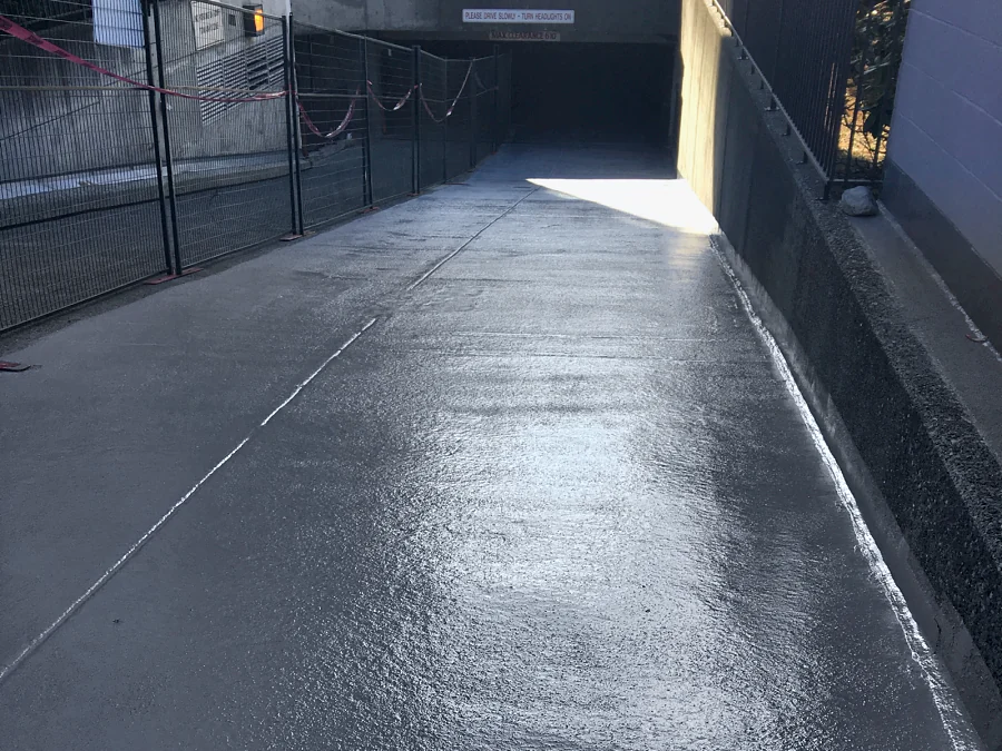 The entrance ramp of a commercial building parkade in North Vancouver finished in a textured grey Tremco Vulkem traffic coating