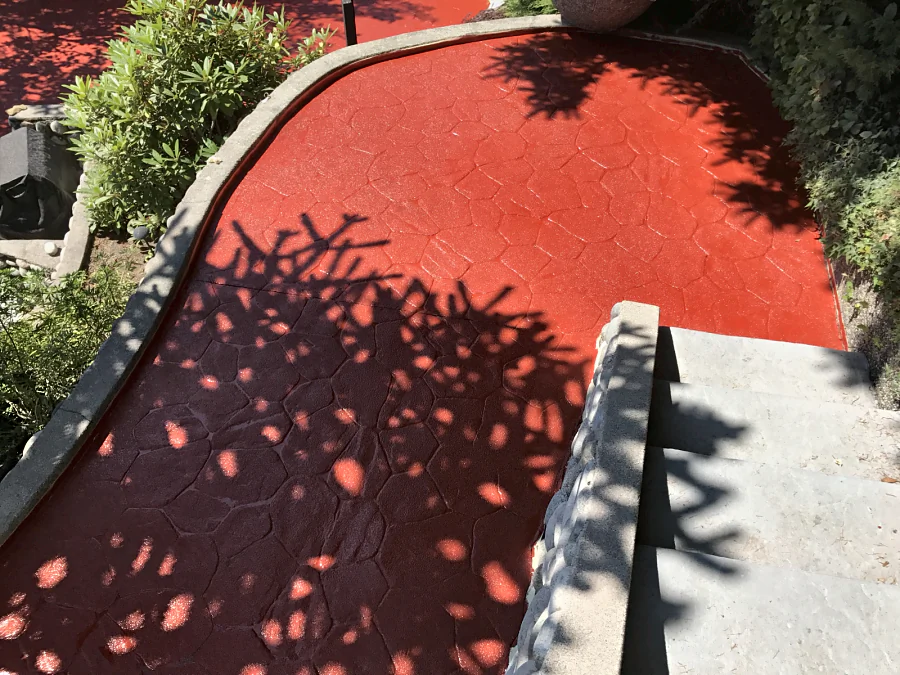 The red ResinTech CRU anti-slip coating on a stamped-concrete walkway down to the stairs at a North Vancouver home