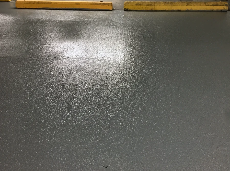 The grey traffic coating laid up to the yellow wheel stops in the Sandman Hotel parkade, Downtown Vancouver, 2017
