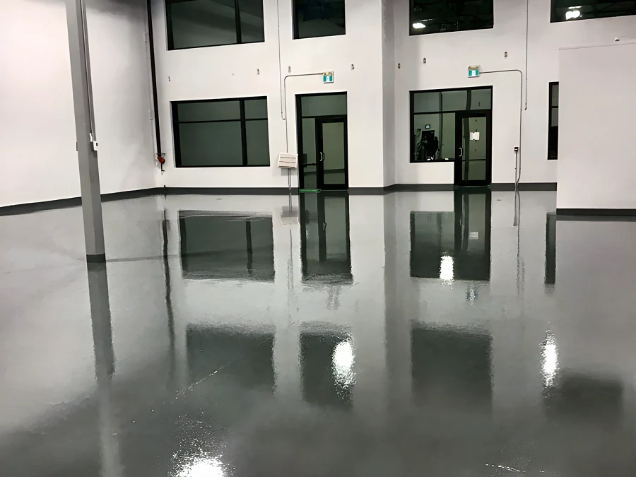 Glossy grey 100% solids epoxy floor in a Surrey warehouse with tall windows