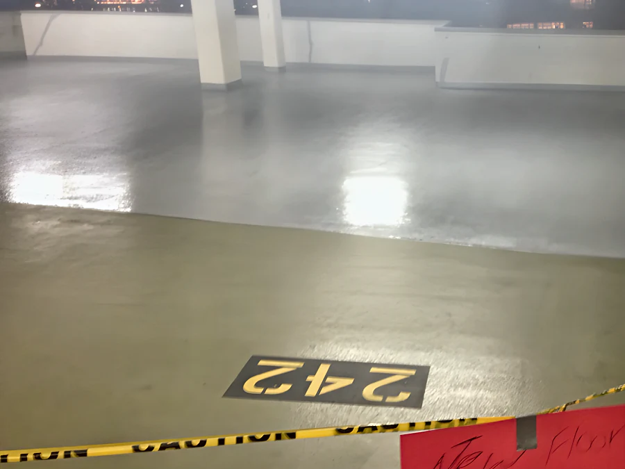 The Three West Centre parkade in Richmond taped off and signed closed, the fresh grey traffic coating rolled out beyond the tape