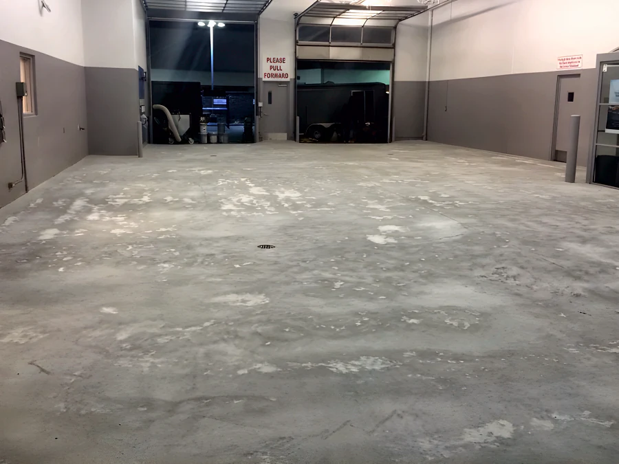 The bare, prepared concrete slab of the service drive at a Toyota dealership’s old shop in Vancouver, before coating
