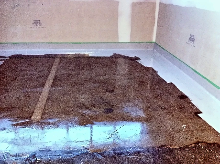 A grey coved base formed at the walls of a UBC Biological Sciences Building laboratory, the first coat going onto the slab