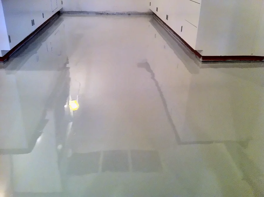 Fresh light grey coat laid between the lab casework in the UBC Biological Sciences Building, glossy under the work light