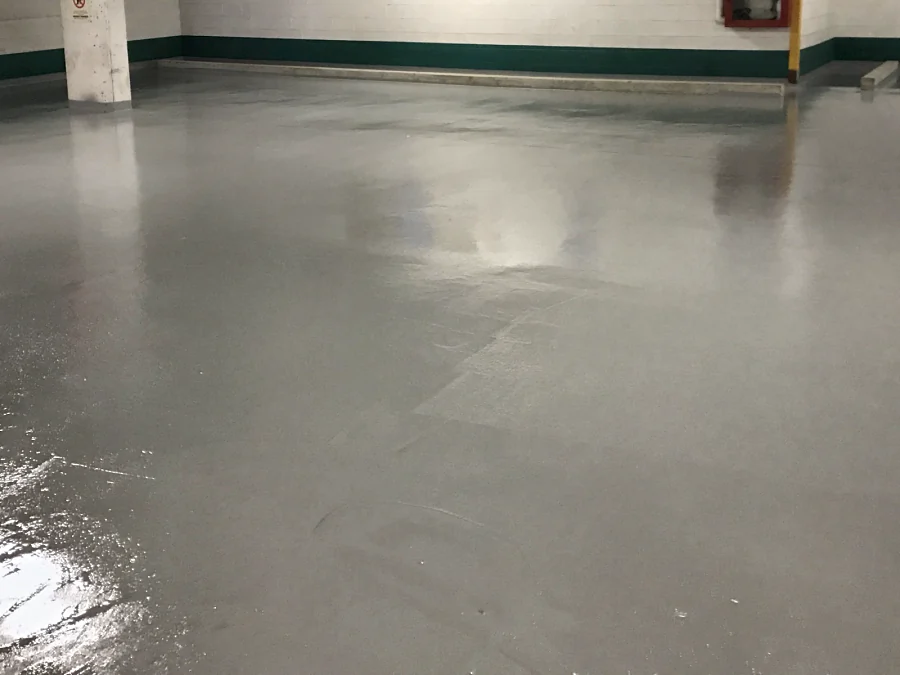 A parking level of the Vancity parkade in Vancouver finished in a glossy grey traffic coating up to the wall base