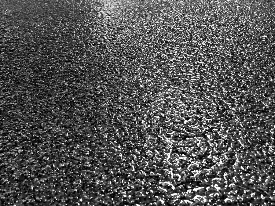 Close view of the textured epoxy and urethane finish on the warehouse floor, the grain catching the light