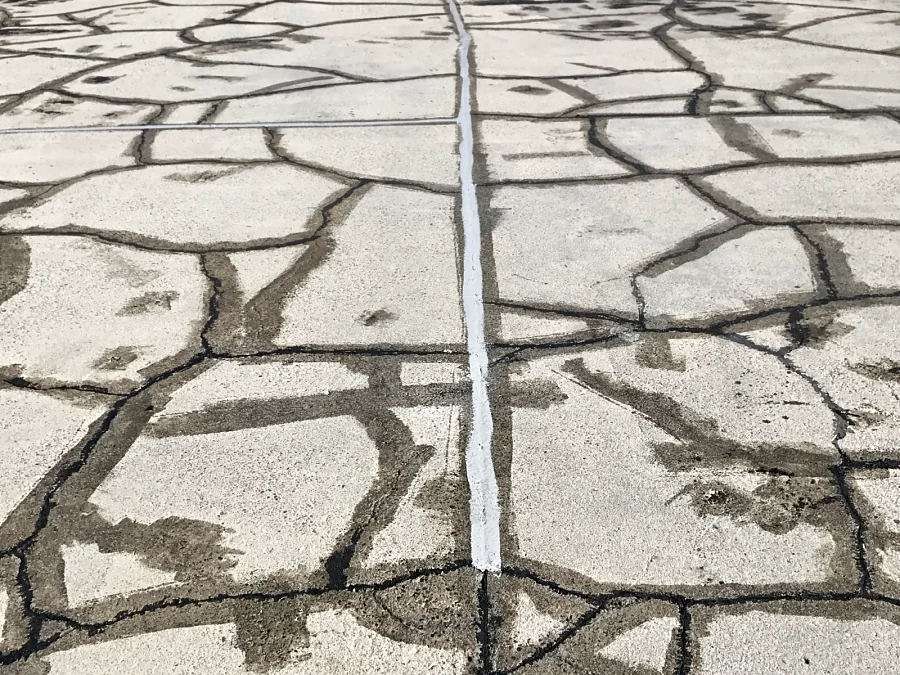 The dense network of cracks across the same exterior parkade deck repaired before the traffic membrane