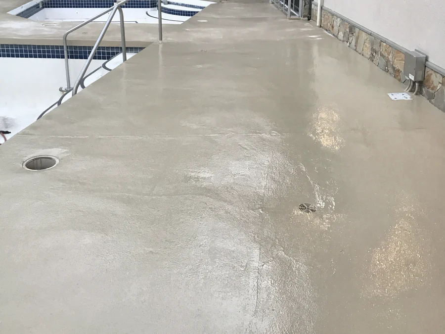 The recoated deck along the pool and the hot tub